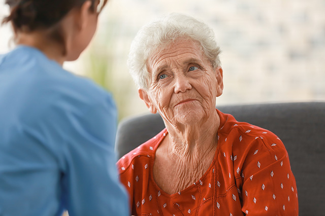 Senioren blickt skeptisch Pflegerin an
